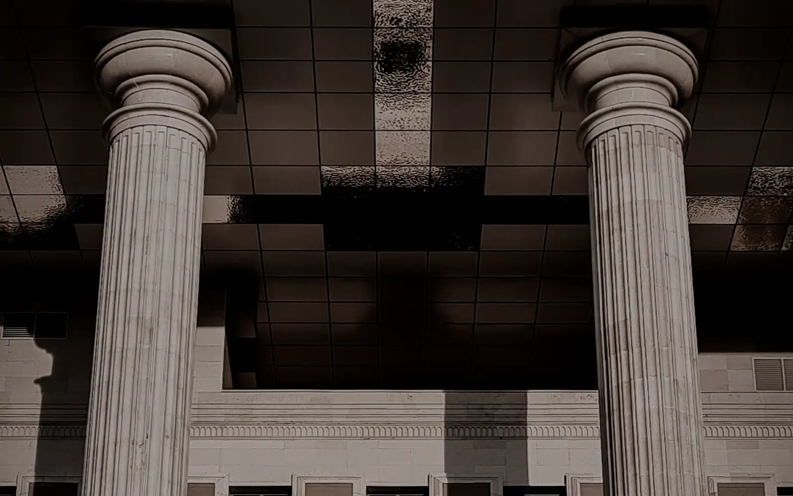 Muted stone facade with classical columns, in shadow